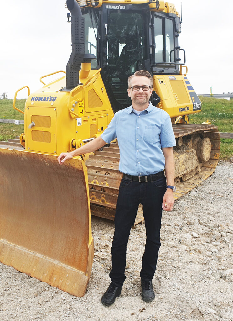 Thord Wreter, försäljningschef på Söderberg & Haak framför en bandschaktare från Komatsu.