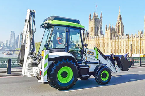 A-hydrogen-JCB-digger-drives-over-Westminster-Bridge-past-Houses-of-Parliament